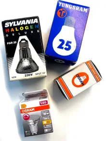 Alte Verpackungen von Halogen- und Glühlampen neben einem modernen Osram LED-Spot GU10
